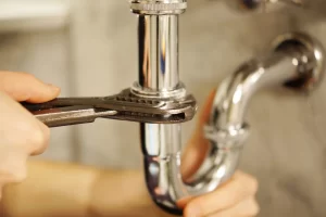 Plumber fixing bathroom sink doing emergency plumbing Calgary, AB