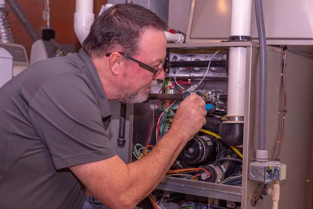 HVAC Technician Working On A High Efficiency Gas Furnace Calgary, AB