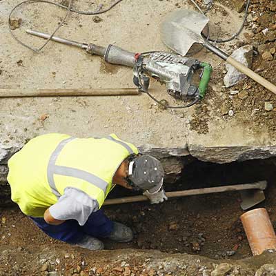 A person fixing a brown pipe doing sewer line repair in Calgary, AB