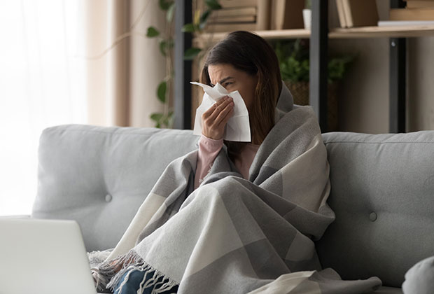 A woman sneezing from a napkin due to poor Air Purification in Calgary, AB.
