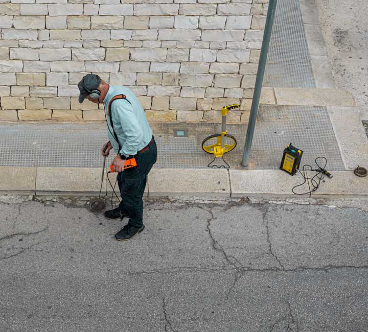 Technician with water leak detector device doing water leak detection services in Calgary, AB