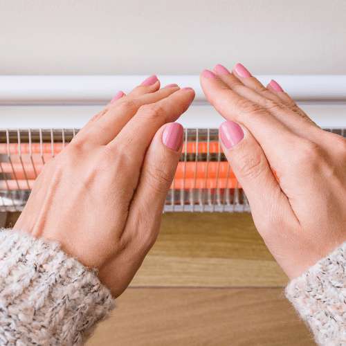 Two hands warming up in front of an electric heater in ProStar.