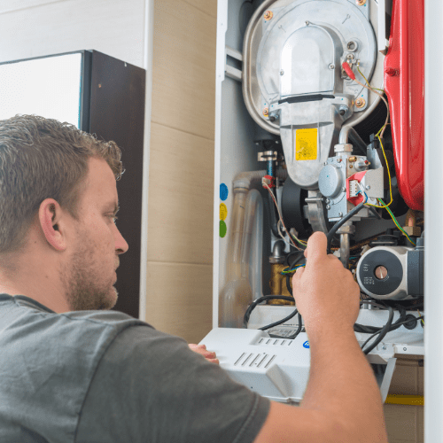 A technician installing a furnace in a residential home, showing the high-quality service provided by ProStar.