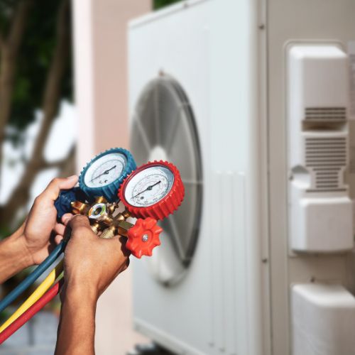 A Prostar Plumbing & Heating plumber holding a air pump in a process of heat pump installation in Calgary AB