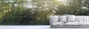 Couch on a terrace with a volume of trees and fresh air on the background in Calgary