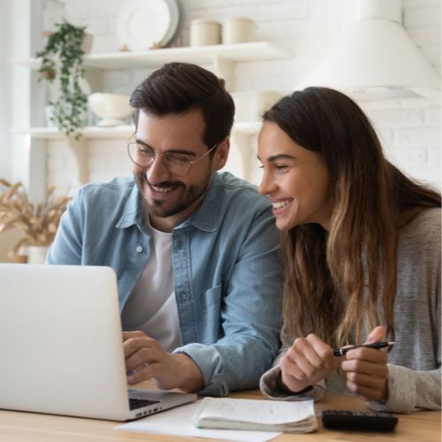 Couple looking at the laptop searching for plumbing services in Calgary, AB