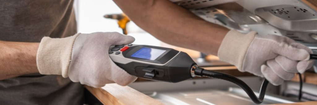 Person using a handheld diagnostic device on an appliance in Calgary.